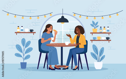 Indian woman and her African friend are drinking tea together. Smiling women gossiping spending time at cafeteria. Cheerful diverse friends are gathered at cafe, enjoying coffee break and conversation