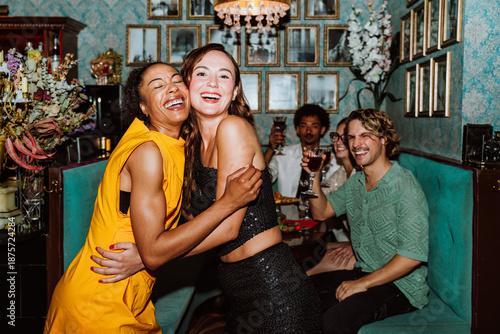 Happy friends hugging at a joyful party in a restaurant