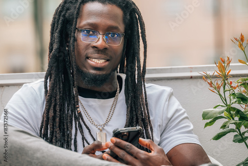 Wallpaper Mural young african man with dreadlocks and mobile phone on the terrace Torontodigital.ca
