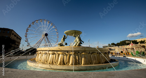 Foto Majestic Tritons fountain by the City Gate of Valletta under a vibrant sky