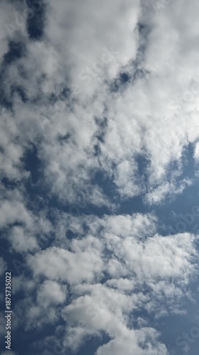 
Vertical time lapse of white clouds moving through a blue sky slowly clearing to a full blue sky
