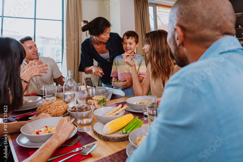 Family and friends reunion at home. Happy multigenerational family enjoying meal together at home