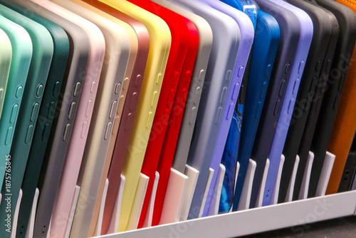 Colorful smartphone cases neatly arranged in vertical row on retail display shelf