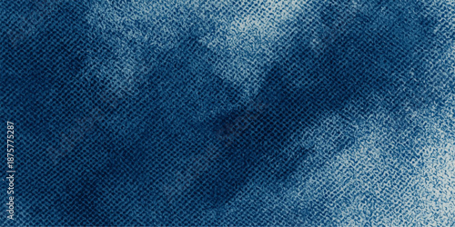 A closeup macro of blue indigo denim fabric reveals a textured cotton material pattern, perfect for a fashion clothing background or textile surface design on worn jean pants