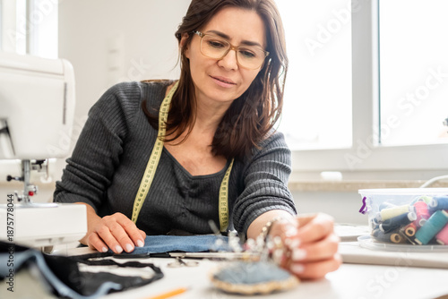 Woman Sewing At Home And Takes The Needle