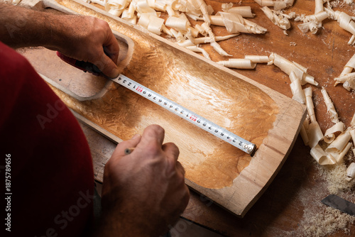 The master measures the distance on the tagelharpa billet with a ruler