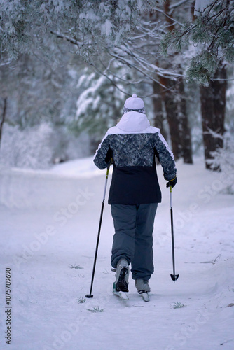 Woman cross-country skiing snowy forest