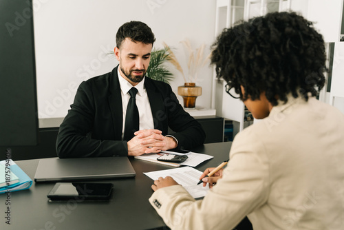 Woman signing financial contract document during a professional business consultation in the bank office