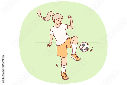 Little girl plays football with ball during outdoor training session preparing for school tournament