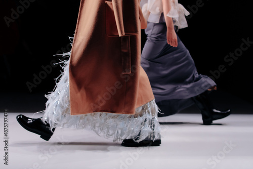 Chic satin brown skirts and blouses, fashion woman's luxury outfits on black background.  Fashion models walking the runway during a fashion show. 