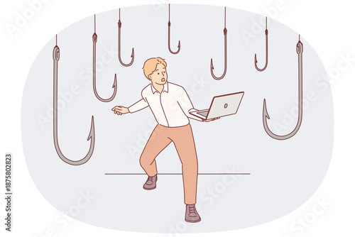 Trap hooks around man with laptop as metaphor for dangers of deception and scammers on internet
