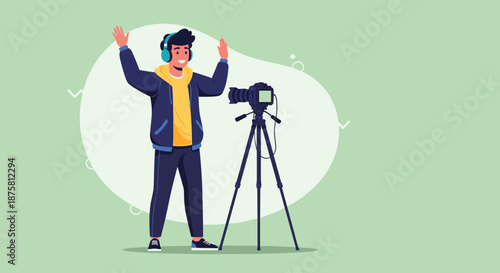 Enthusiastic young man with headphones recording a video using a professional camera on a tall tripod in a studio.