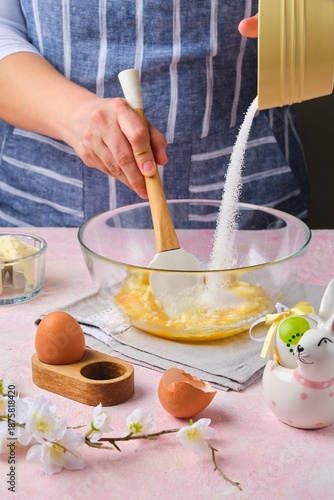 Step by step preparation of Easter cake or other Easter pastries on pink concrete background. Rubbing butter with eggs and sugar. Happy Easter.