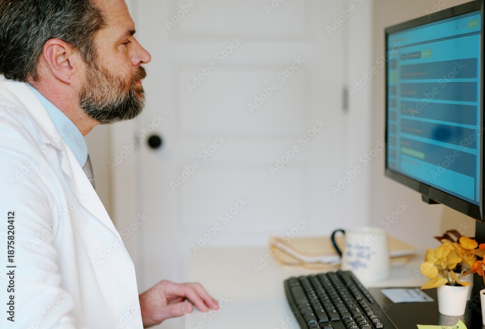 Fototapeta premium Middle-aged male doctor in home office reviews patient EMR dashboard with AI-assisted notes, vitals, labs, and visit summaries on monitor concept