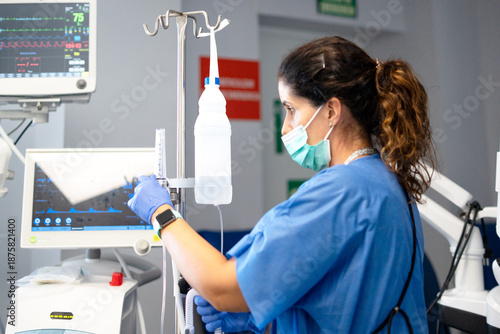 Tableau sur toile Nurse adjusting emergency medical equipment in icu