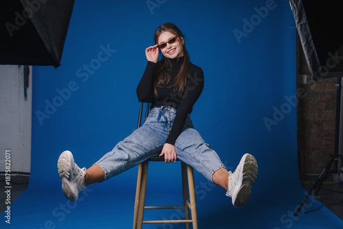 Dynamic female subject posing confidently with studio equipment nearby