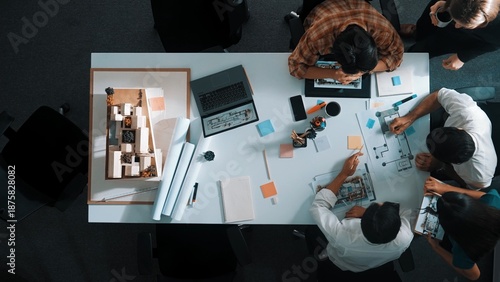 Bilde på lerret Top aerial view business people brainstorming about building interior at table with house model and laptop displayed house plan while architect engineer drawing and writing at blueprint