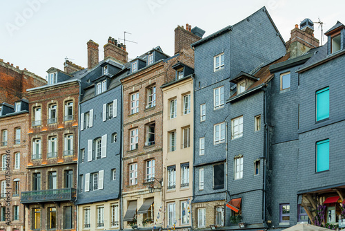 Foto A row of old, narrow, tall buildings of various types in a town Honfleur in Normandy, France