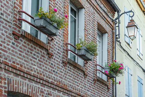 Slika na platnu The building has three window boxes with flowers in them in France