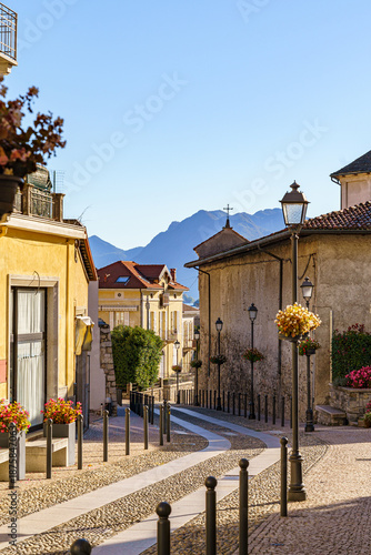 A cozy old street in the town of Baveno on Lake Maggiore in Italy The silhouette of the mountains can be seen in the background.