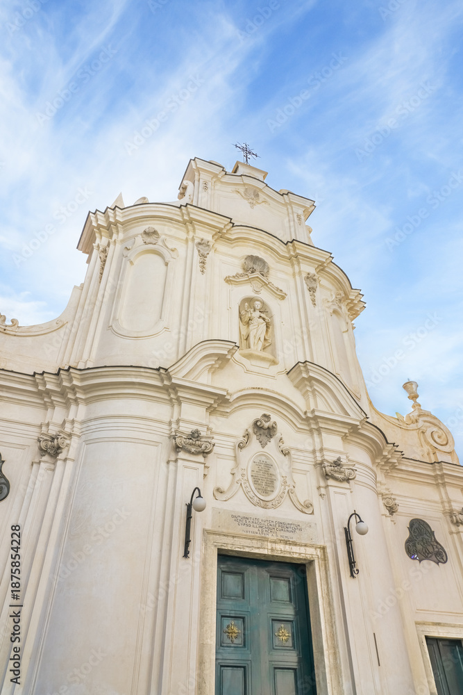 Obraz premium White baroque church façade in Atrani on the Amalfi Coast, Italy, featuring elegant curves, sculptural details, and a historic Mediterranean atmosphere under a blue sky.