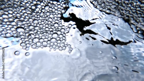 Bottom-up view, air bubbles in white foam on the surface of freshwater flowing from underground springs into the Black Sea