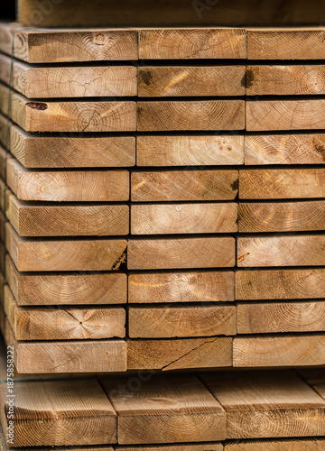 Stacked wooden lumber planks with visible growth rings.