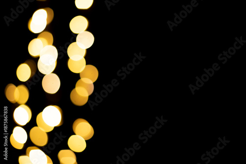 Golden blurred bokeh lights on black background. Christmas lights overlay.