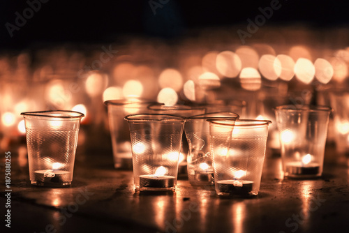 Obraz na płótnie Candlelight vigil with small candles in plastic cups at night, remembrance conce