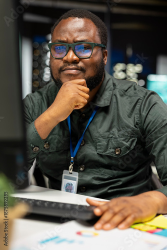 Vászonkép African american businessman strategizing late at night in the office, thinking about ways to achieve a successful career