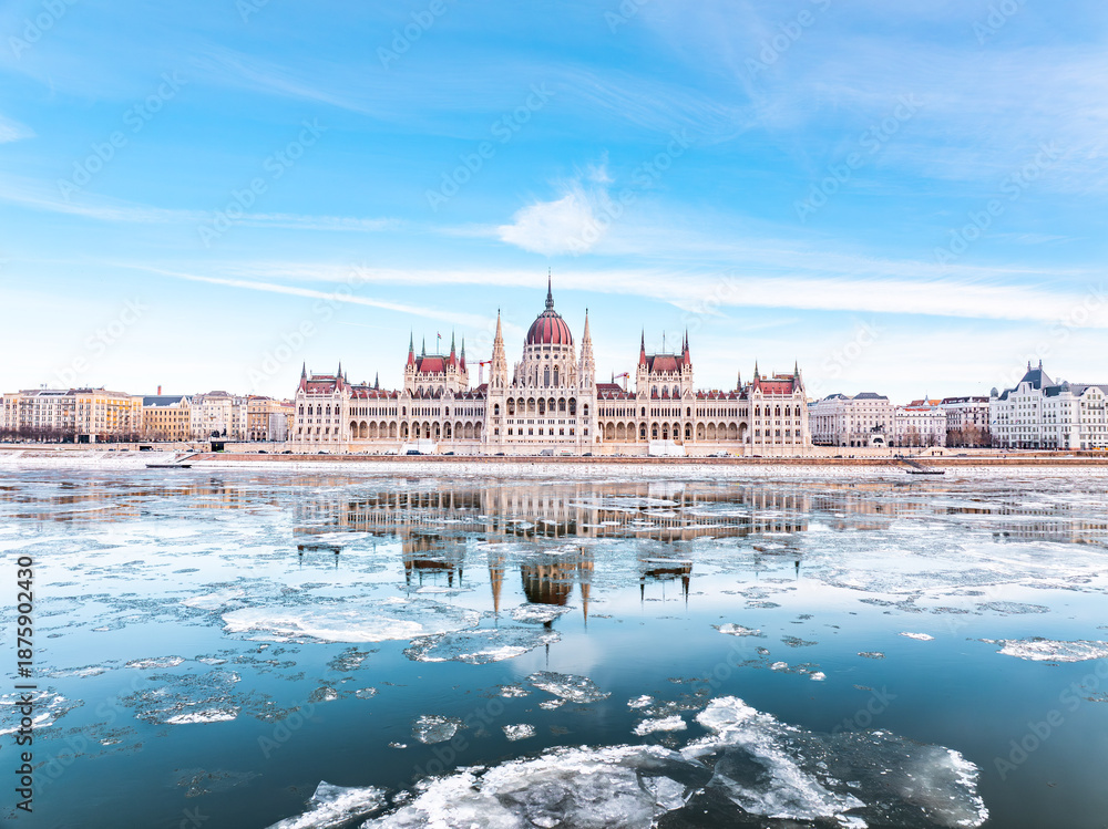 Naklejka premium The Parliament of Hungary in Icy Winter time and it's mirrored picture on the freezing Danube, Budapest Hungary