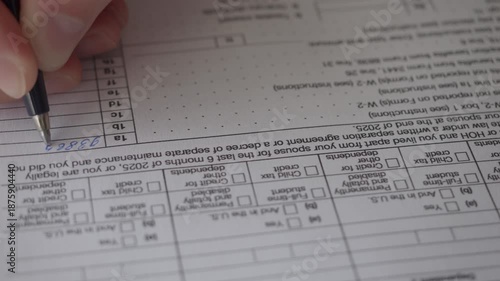 Man Filling In The Tax Form 1040 for 2025 Year. Person Calculates of Planning Budgets Yearly Personal Finance and Fills up US Tax Form 1040 For 2025 Year. Signing 1040 Income Tax Return For 2025 Year.