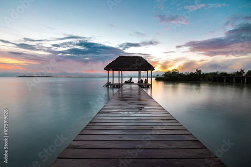 Larga exposición de un hermoso amanecer en un muelle en la laguna de Bacalar, Quintana Roo, México, contraluz