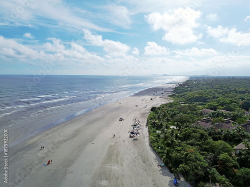 Aerial view of the Guarajuba beach in Bertioga, Brazil, long beach in Atlantic Ocean. Summeer time, tourists on beach sand