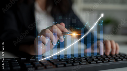 Fotografi A business professional examines digital financial data on a keyboard, highlighting growth trends through a clear chart, representing strategic investment insights