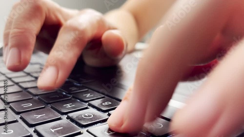 Side view Close up of fingers typing on a laptop keyboard, focusing on black keys, symbolizing technology, digital work, communication, productivity, and the modern lifestyle of online activity