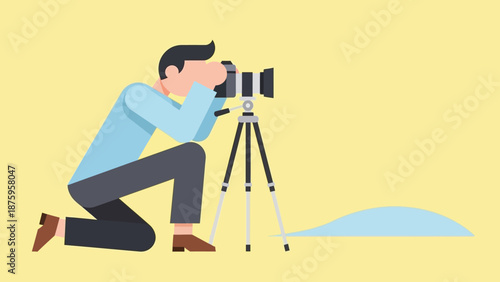 Man crouching and taking a photograph with a camera on a tripod.