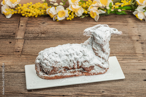 Easter lamb cake with traditional spring decor. Baked sweet dessert with icing. Festive background