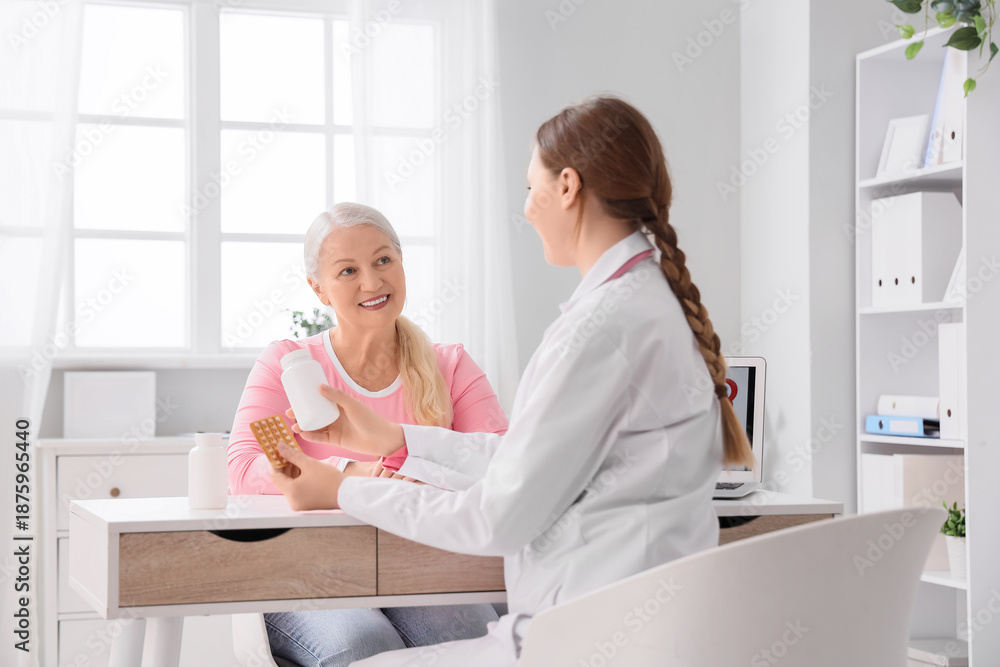 Obraz premium Female gynecologist prescribing pills to patient at table in clinic. Menopause concept