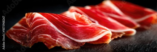 Close-up slices of Spanish jamon. Ham meat texture background. Wide panoramic shot of traditional European culinary delicacy