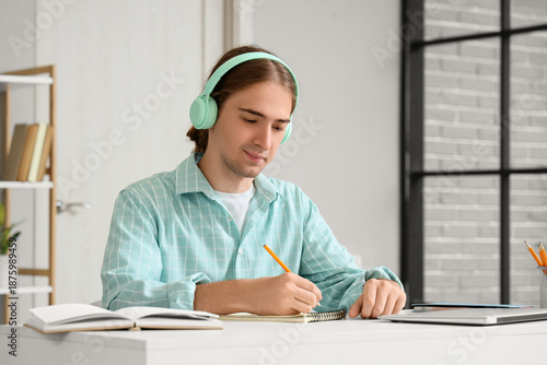 Young man in headphones wri...