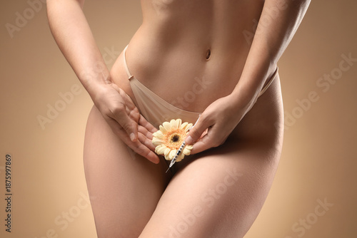 Foto Young woman in panties with flower on beige background, closeup