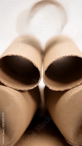 Arrangement of Recycled Cardboard Tubes in a Pyramid Formation on White Background