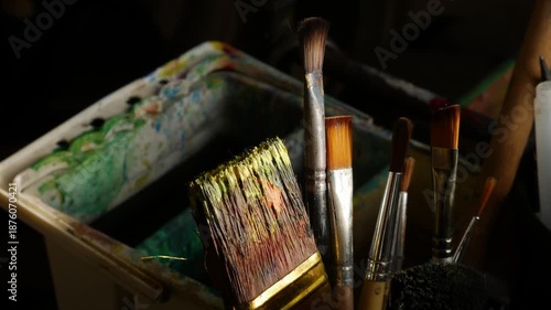 Collection of Used Artist Paintbrushes in Container with Paint Palette 