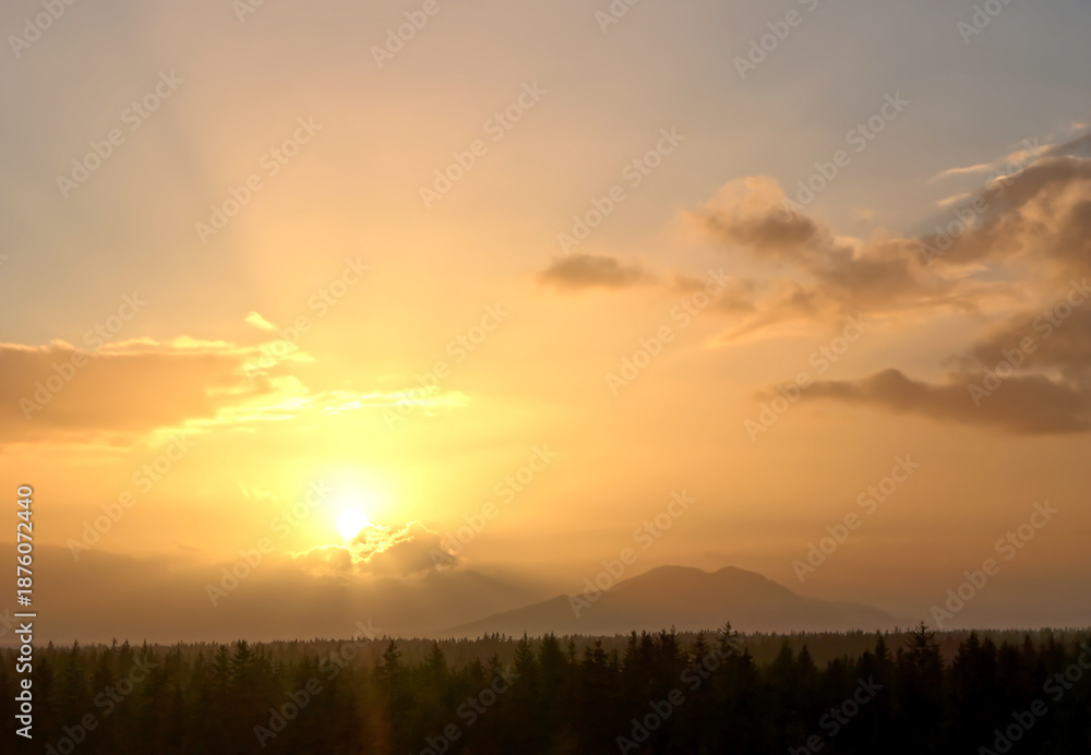 Obraz premium Scenic sunset with clouds, mountains, and forest in Southeast Alaska