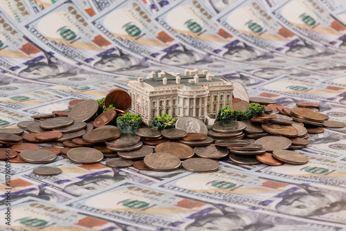 The symbolic building of the US President's residence - the White House and American coins against the background of $100 bills