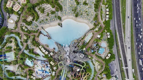 Aerial view of Volcano Bay water park with volcano, pools, slides and nearby highway traffic in Orlando, Florida, USA. g.