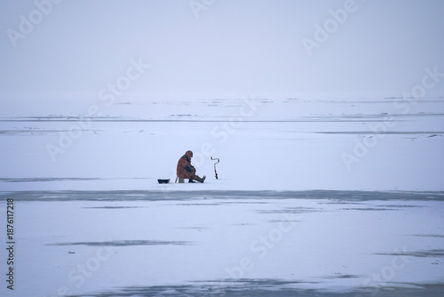 Ice fishing. a single man catches a perch.