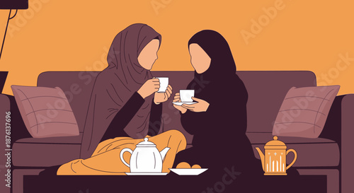 Two Muslim women in hijabs enjoy a peaceful tea time together on a comfortable sofa, sharing conversation and warmth in a cozy home setting.