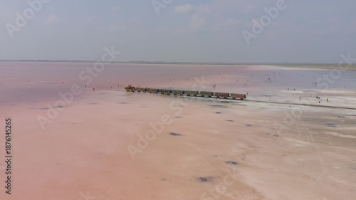 Burlinskoye Lake (Bursol), Altai Krai — Pink Salt Lake. A train‑like vehicle moves along the shore.